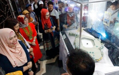 <p><strong>MINIATURE MOSQUES.</strong> Autonomous Region in Muslim Mindanao officials led by Regional Executive Secretary Laisa Alamia (extreme left) and Anak Mindanao executive director Sitti Djalia Turabin Hataman (in red Muslim dress) looks at one of the miniature mosques placed on exhibit at the ARMM compound in this city on Friday (May 11). <em><strong>(Photo by BPI-ARMM)</strong></em></p>